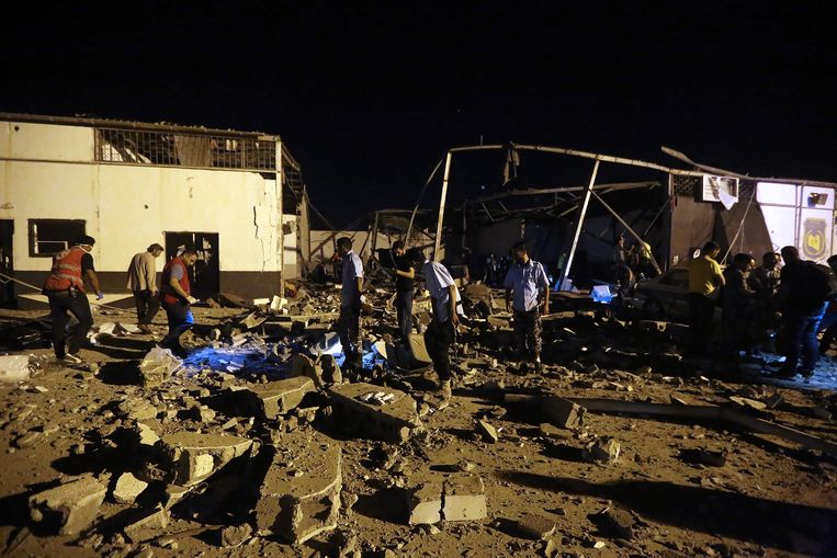 Hulpdiensten verbergen de lijken na een luchtaanval op een detentiecentrum in Libië. Beeld AFP
