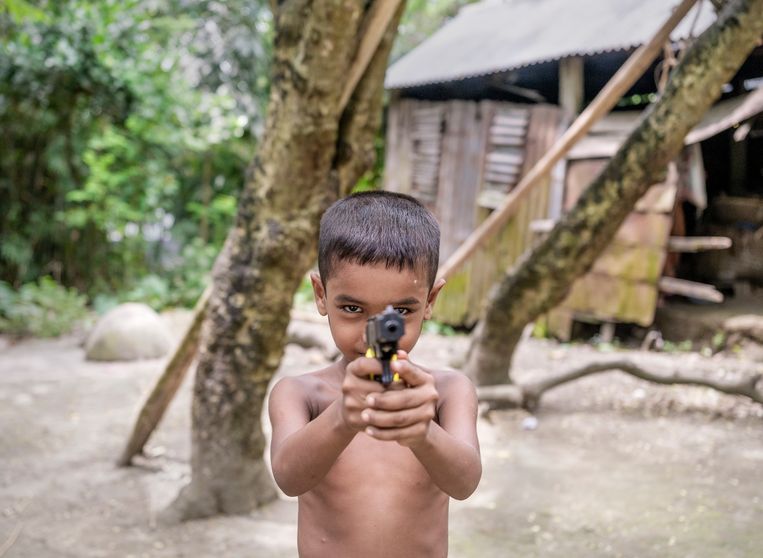 Fahadul, het zoontje van Suman, mag graag spelen met een plastic pistool, een van de weinige stukken speelgoed die hij heeft. Beeld Patrick Post