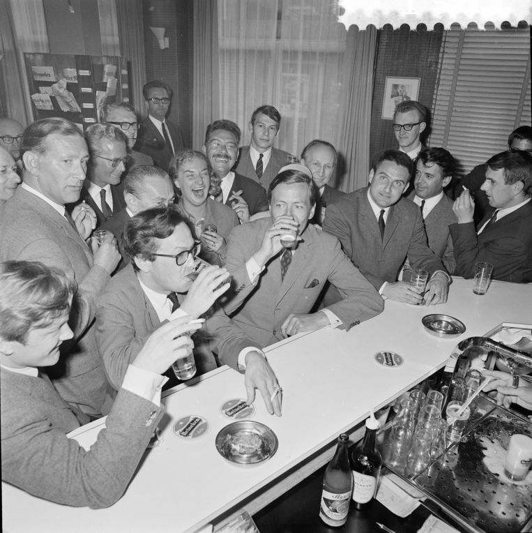 Prins Claus drinkt een pilsje te midden van de journalisten aan de bar tijdens een bezoek aan perscentrum Nieuwspoort, 1967. Beeld ANP /  ANP
