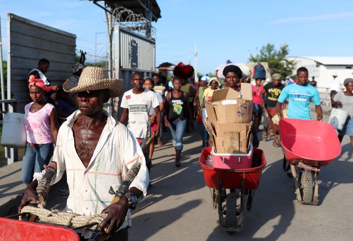 Haïtianen steken de grens met de Dominicaanse Republiek over om producten op een lokale markt te gaan verkopen.