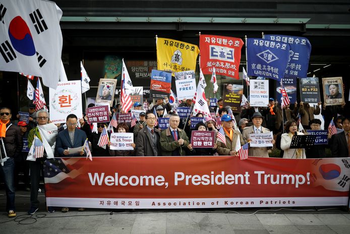 Demonstranten verwelkomen president Trump in Seoel.