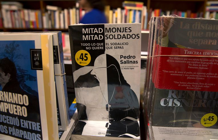Het onthullende boek 'Half monniken, half soldaten' van Paola Ugaz en Pedro Salinas in een boekhandel in Lima, Peru.  Beeld AP