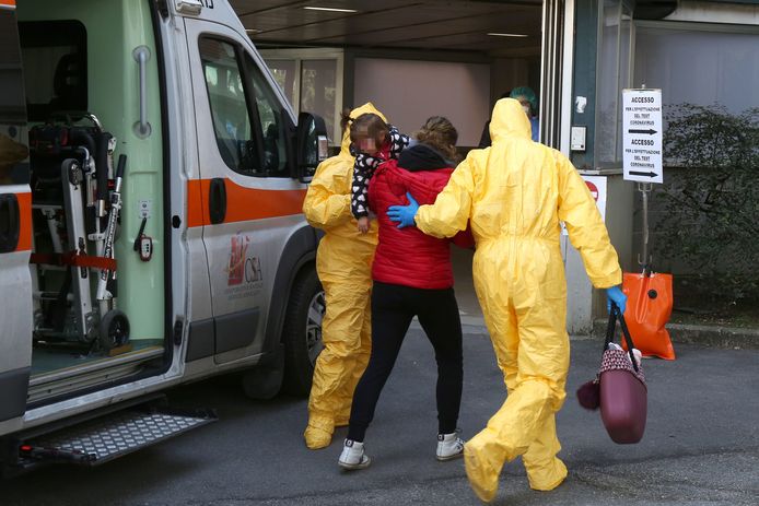 Gezondheidswerkers begeleiden een vrouw met kind in de armen naar het ziekenhuis van Padua.