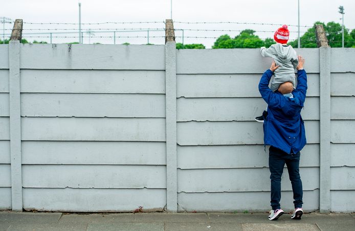 Een jonge fan van Liverpool probeert een glimp op te vangen van de sterren van de Engelse kampioen.