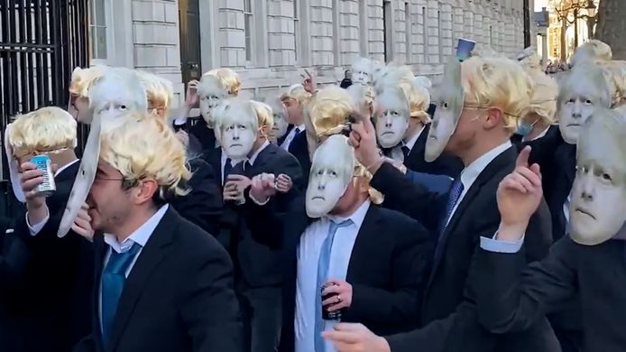 Groep mannen verkleed als Boris Johnson dansen aan zijn ambtswoning