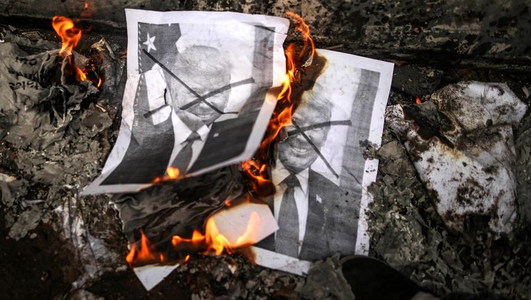 Palestijnen verbranden posters van President Trump tijdens een protest tegen zijn beslissing om Jeruzalem officieel te erkennen als hoofdstad van Israël. Beeld epa
