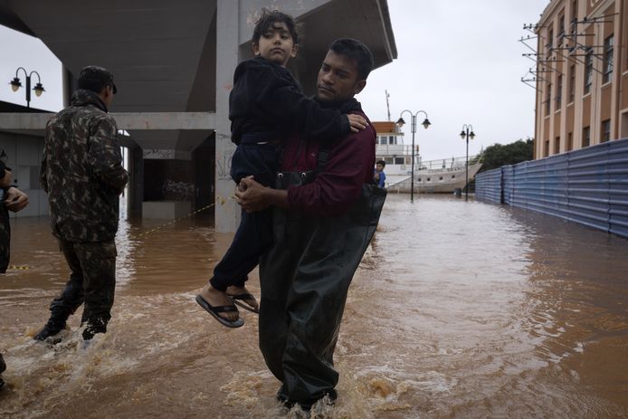 Een vader probeert zich met zijn zoon in veiligheid te brengen in Porto Alegre, de hoofdstad van de door het noodweer zwaar getroffen Braziliaanse deelstaat Rio Grande do Sul.