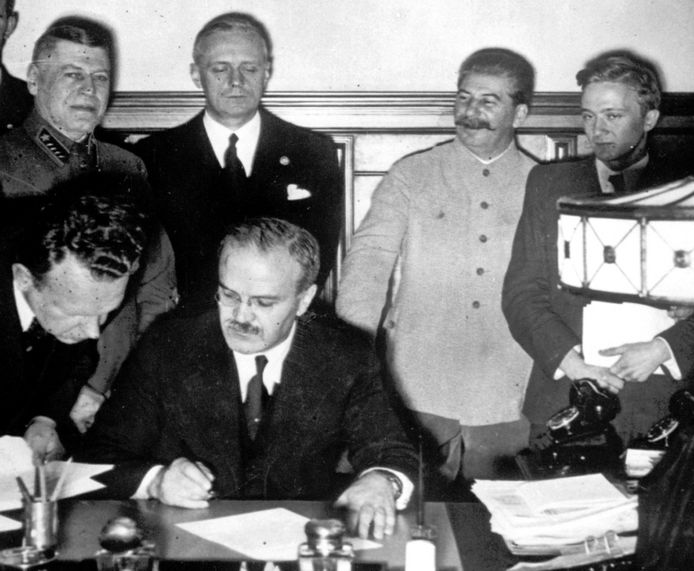 Photo de la signature du pacte. En haut, Ribbentrop (2e de gauche à droite) à côté de Staline (2e de droite à gauche). Assis, Molotov en train de signer le fameux pacte.