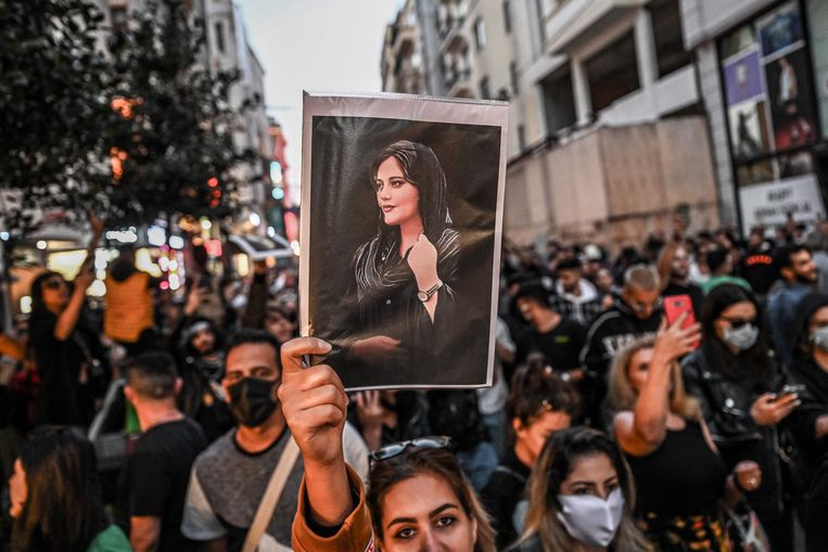 Betogers tegen het islamistische regime in Iran voeren een portret van de 22-jarige Mahsa Amini met zich mee, die in september 2022 werd vermoord door de Iraanse religieuze politie. Beeld AFP