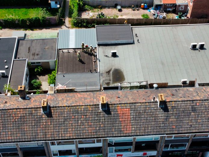 De brandweer bestudeert het gat in het dak boven de winkel in Veenendaal.