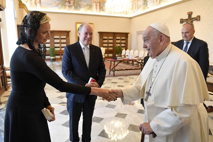 Prinses Charlene van Monaco schudt een hand met de paus.