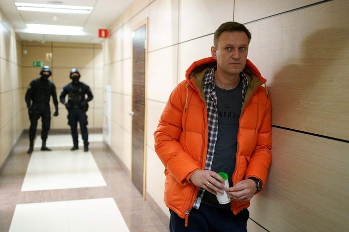Alexei Navalny aan zijn kantoor in Moskou, met twee gemaskerde agenten in zijn kielzog. (Foto uit december 2019)