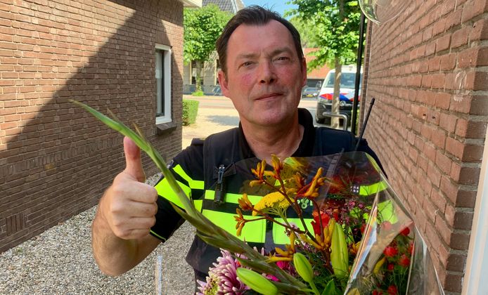 Wijkagent Ton Minnen is blij met oplettende wandelaars en brengt een bloemetje.