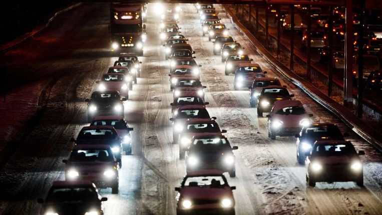 Auto's rijden stapvoets door de aanhoudende sneeuwval Beeld anp