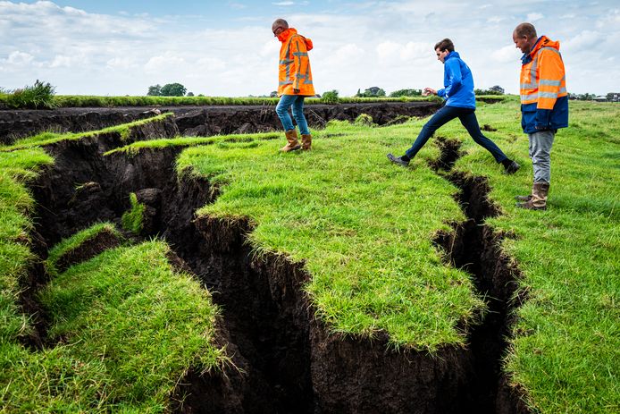 Waterschapsmedewerkers Johan Schoon, Bas Knapp en Rob Mensink (v.r.n.l.) inspecteren de plek van de dijkdoorbraak.