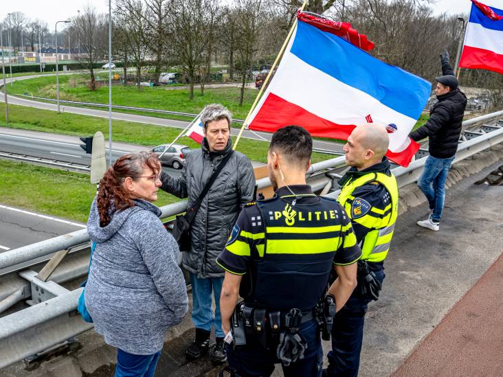 Demonstranten met omgekeerde vlaggen eisen vertrek Rutte op A59-viaduct bij Raamsdonksveer