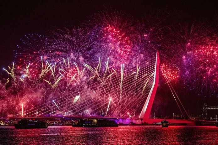 Feestvierders vieren de jaarwisseling bij de Erasmusbrug in Rotterdam. Op en rond de brug wordt het Nationale Vuurwerk afgestoken.