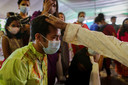 Mensen dragen mondmaskers tijdens een tempelbezoek in Dhaka, Bangladesh.