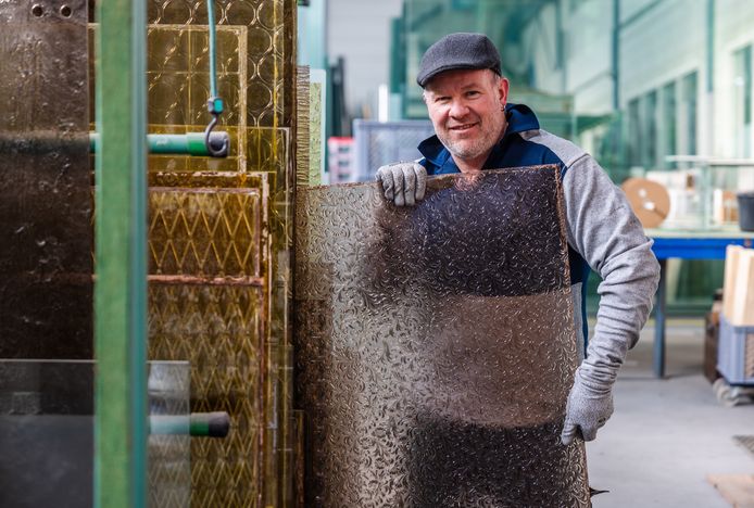 De medewerker Pieter pakt een groot Japans glas met rozenfiguren.  De firma Van Es uit Sliedrecht heeft een kleine 