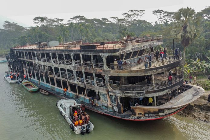 Hulpverleners bergen lichamen van slachtoffers op de uitgebrande veerboot.