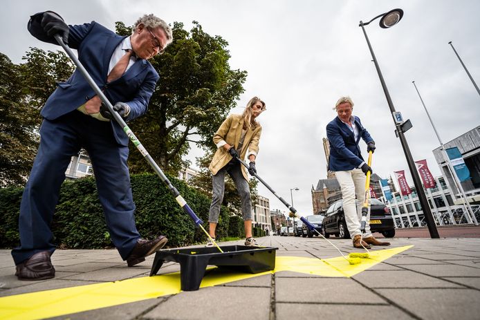 Jan Markink, Manon Flier en Jan van Dellen schilderen een bliksemflits op het trottoir tegenover het Arnhemse stadhuis.