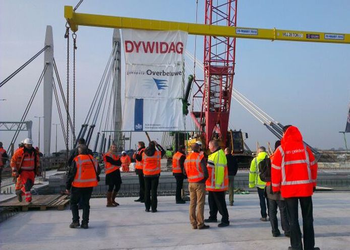 Medewerkers van Rijkswaterstaat donderdagochtend bezig met het plaatsen van de laatste ligger op de brug.
