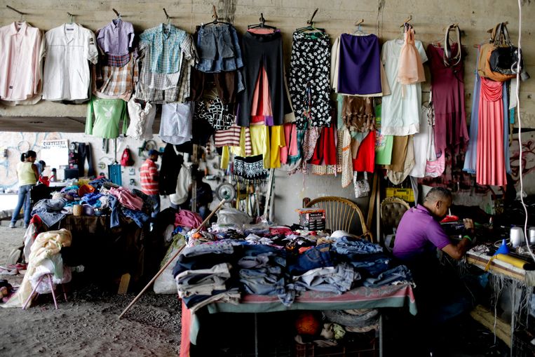 Een geïmproviseerde winkel voor tweedehands kleding in de Venezolaanse hoofdstad Caracas. Het IMF waarschuwt voor groeiende armoede na de coronapandemie in landen die sterk afhankelijk zijn van grondstoffen en buitenlandse familieleden die geld sturen.  Beeld AP