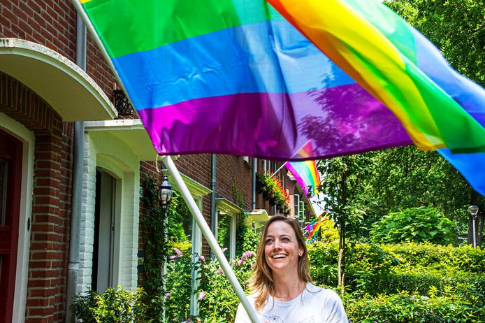 Anne Woltersom wappert haar regenboogvlag door de Leijparkweg op Roze Maandag.