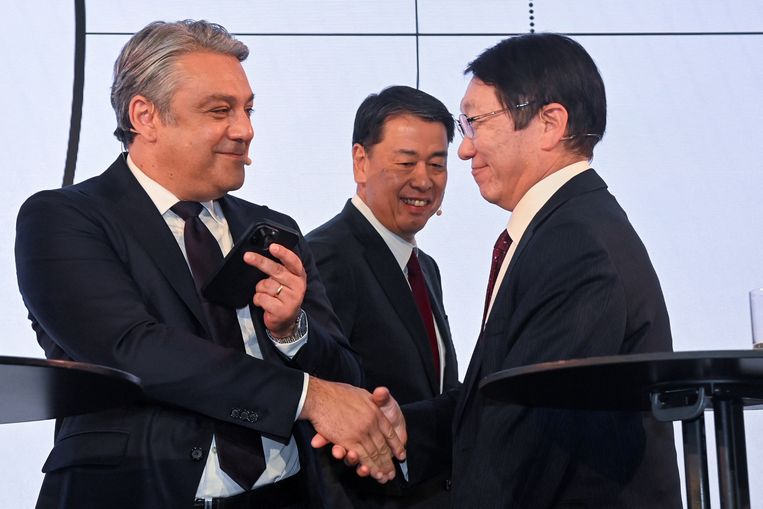 De drie topmannen van de alliantie: ceo Luca de Meo van Renault (links) schudt de hand van Takao Kato, ceo van Mitsubishi. Nissans topman Makoto Uchida kijkt toe tijdens een persconferentie van maandag waarop de nieuwe samenwerking bekend werd gemaakt. 
 Beeld REUTERS
