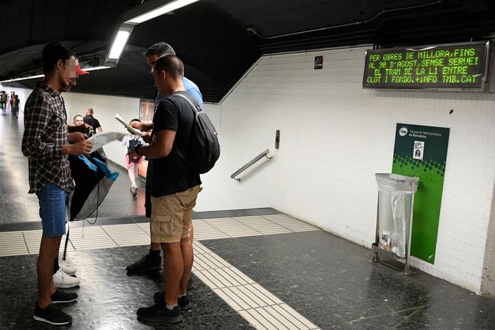 Agenten controleren de papieren van twee van zakkenrollen verdachte jongemannen in een metrostation.