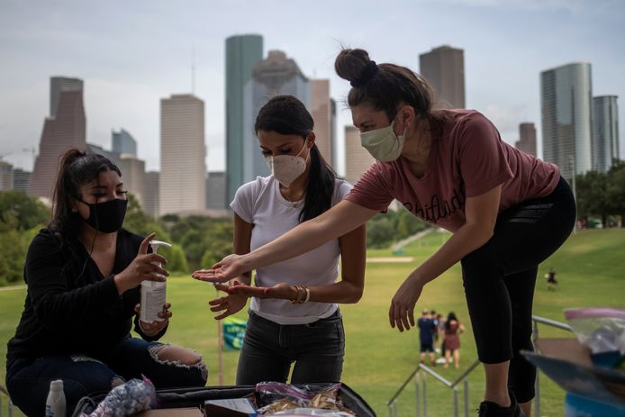 Vrouwen delen handsaniter in Houston, Texas.