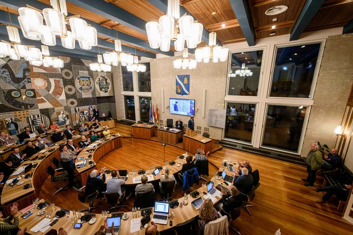 De gemeenteraad bijeen, met links op de wand het mozaïek Werken van Barmhartigheid.