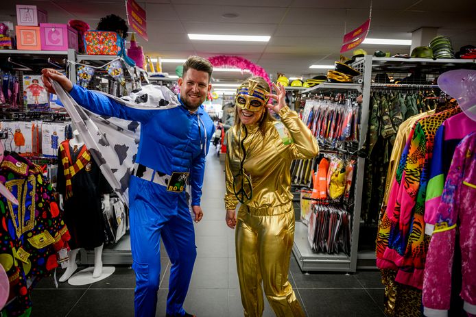 Verslaggevers Fardau Wagenaar (rechts) en Joost Dijkgraaf doken zelf de grootste feestwinkel van Twente in. Het 'superboerenpak' is een bestseller bij de mannen, Fardau schittert deze carnaval in het goud.