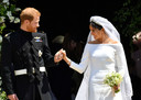Prins Harry en Meghan Markle komen als man en vrouw uit St George Chapel gelopen.