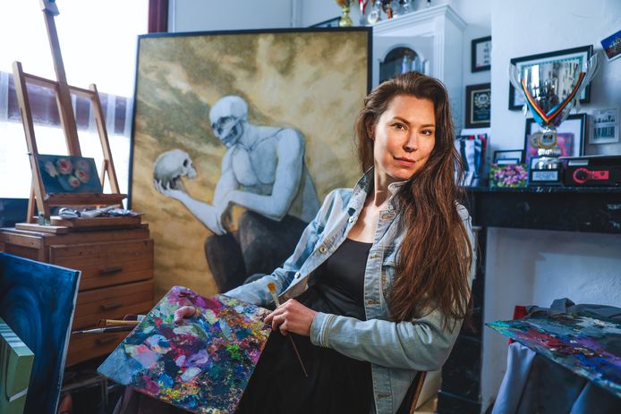 Katrina met op de achtergrond haar schilderij ‘Oorlog’.