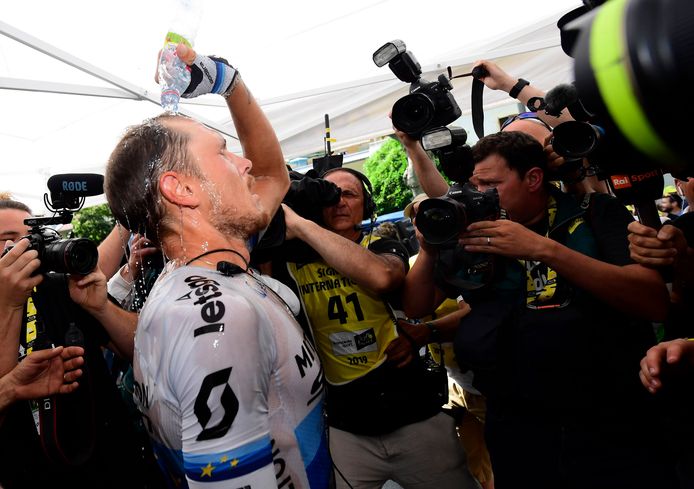 Ritwinnaar Matteo Trentin besprenkelt zich met een flesje water.